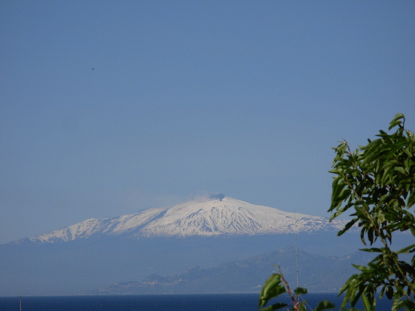 L'Etna innevato visto da Capo dell'Armi, sospeso sopra la foschia dello Stretto